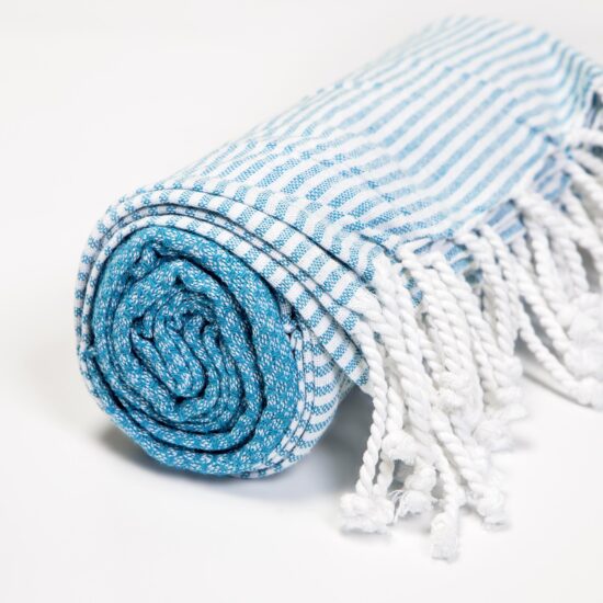 toalha de praia azul em algodão enrolada